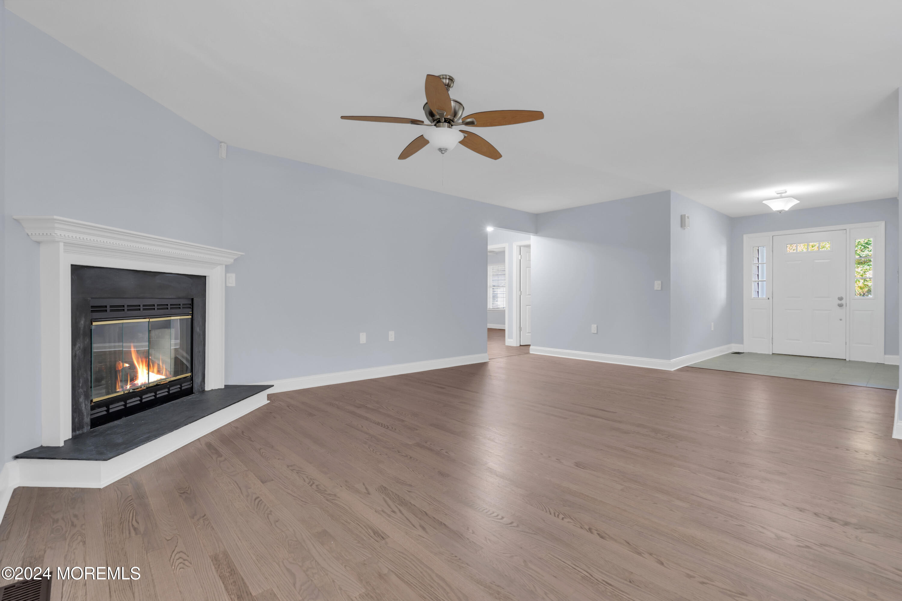 239 Sunset Drive Forked River, NJ 08731 - Photo 8 of 35 a view of an empty room with wooden floor fireplace and a window