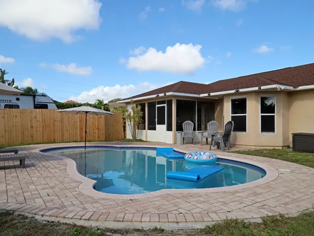 a view of a house with swimming pool and sitting area