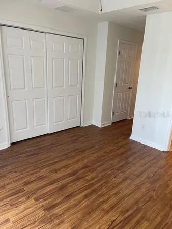 a view of empty room with wooden floor