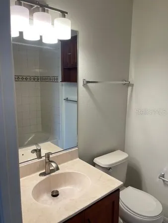 a bathroom with a sink toilet and mirror