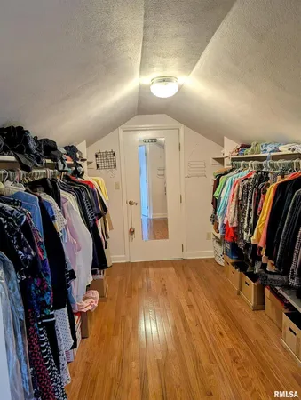 a view of walk in closet with clothes and shoes