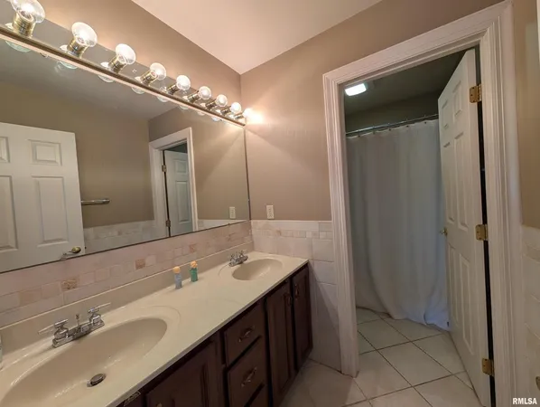 a bathroom with a double vanity sink and a mirror