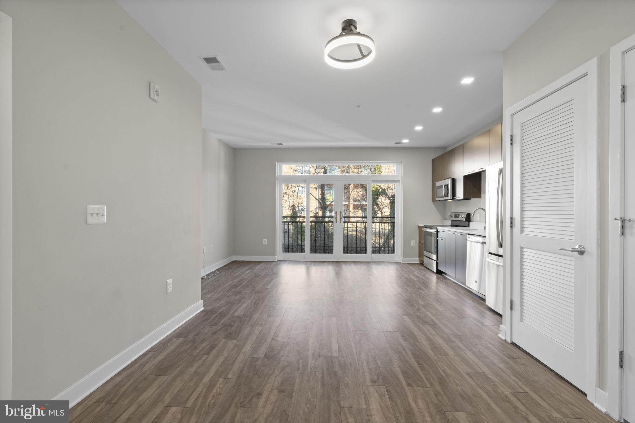 989 South Buchanan Street, Unit 312 Arlington, VA 22204 - Photo 13 of 45 an empty room with wooden floor and windows