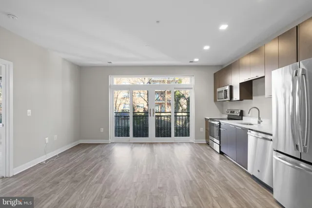 a open kitchen with kitchen island wooden floors and stainless steel appliances