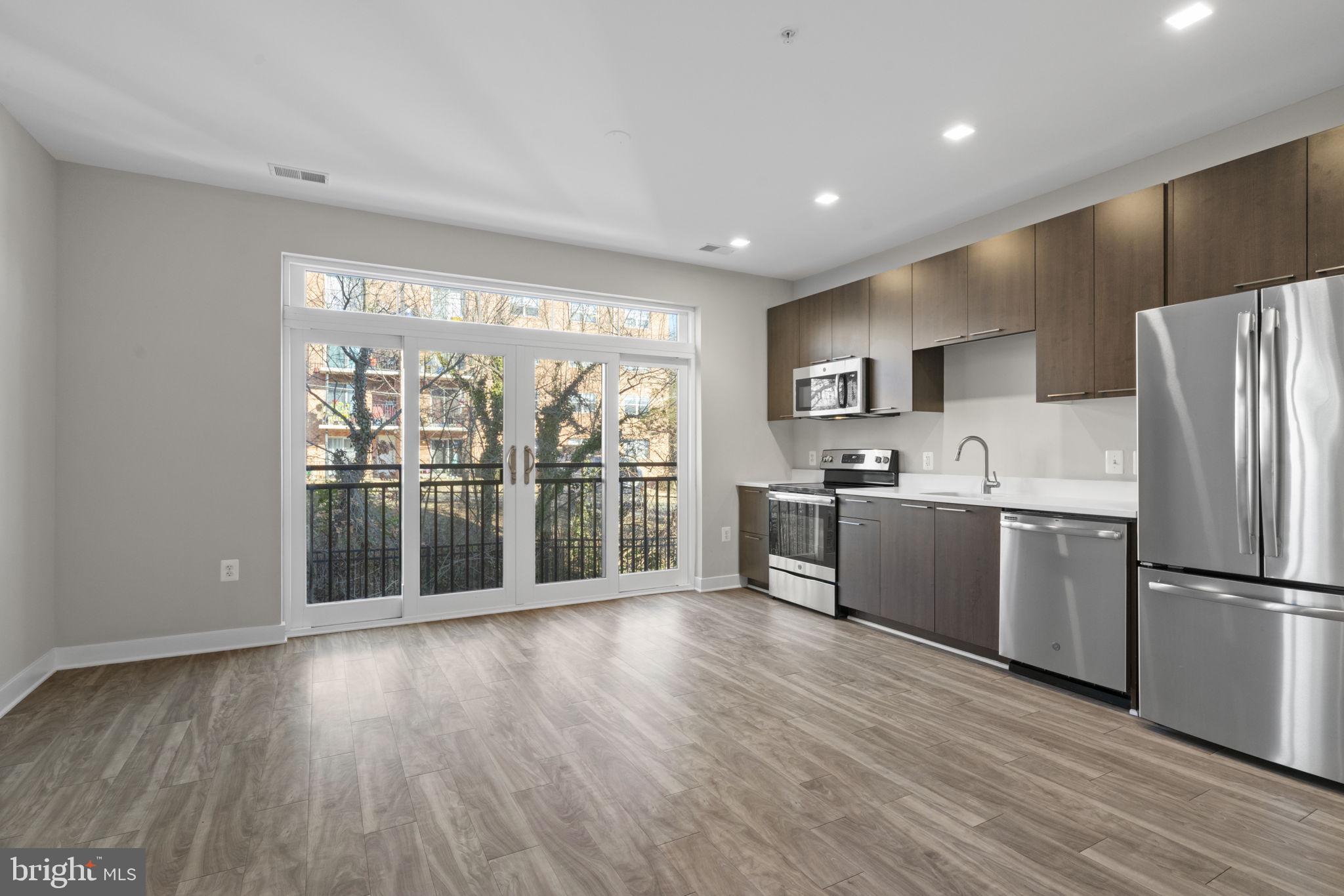989 South Buchanan Street, Unit 312 Arlington, VA 22204 - Photo 15 of 45 a kitchen with a refrigerator a sink and a large window