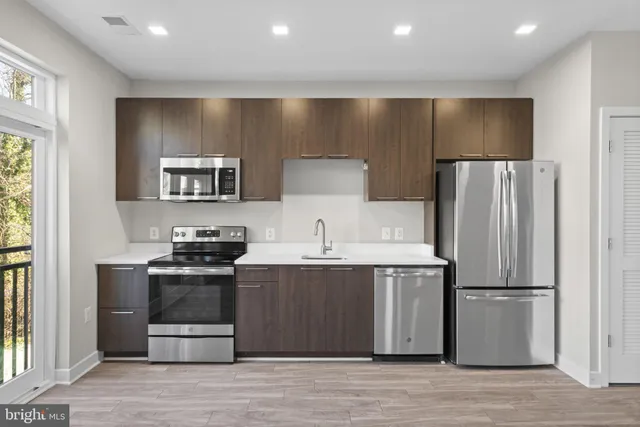 a kitchen with stainless steel appliances a refrigerator a stove and a sink