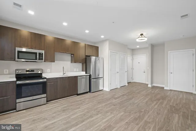 a large kitchen with stainless steel appliances granite countertop a stove a sink and a refrigerator