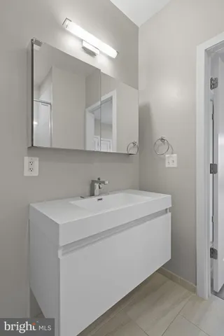 a utility room with a sink a vanity and a mirror