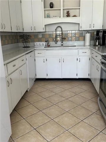 a kitchen with appliances a sink and cabinets