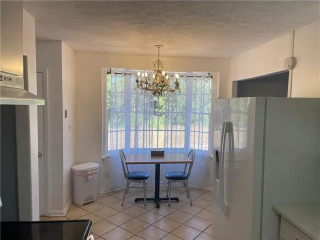 a bedroom with a bed a table and chair