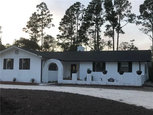 a view of a house with backyard and sitting area