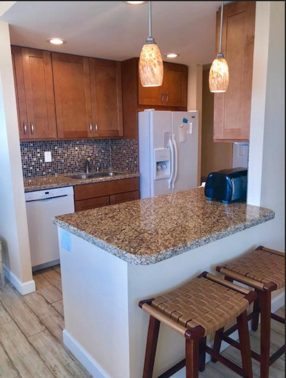2121 North Ocean Boulevard, Unit 1208E Boca Raton, FL 33431 - Photo 13 of 61 a kitchen with cabinets and wooden floor