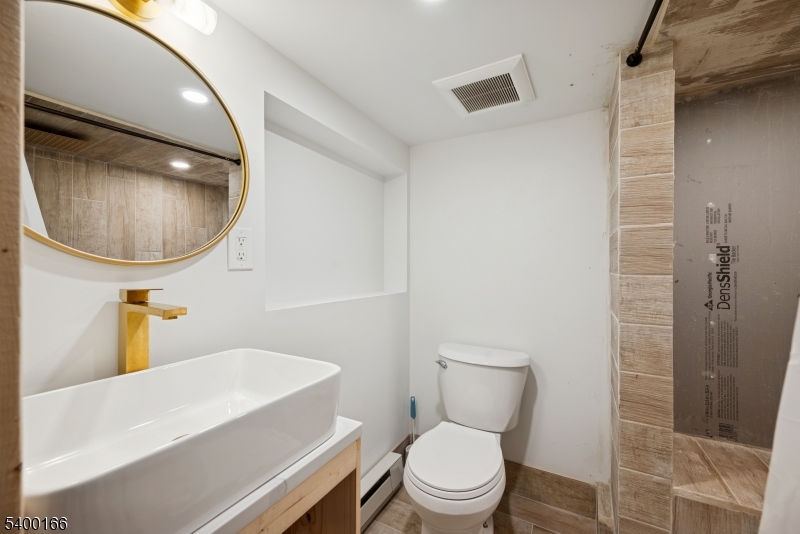 206 Brooklyn Mountain Road Hopatcong, NJ 07843 - Photo 12 of 18 a white toilet sitting next to a bathroom sink and a mirror