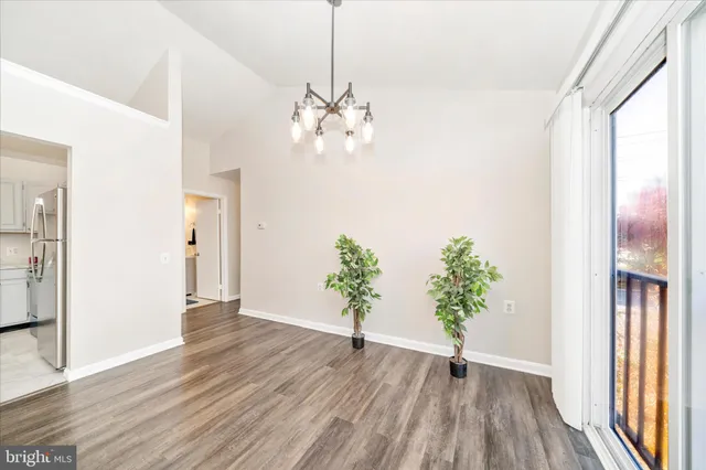 a view of a hallway with wooden floor and a chandelier