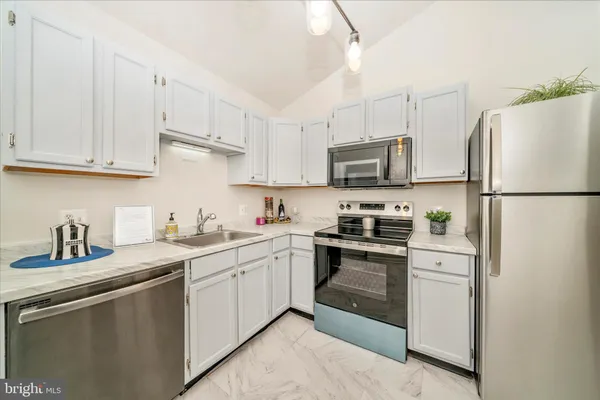 a kitchen with white cabinets and white appliances