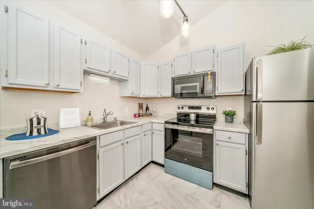 a kitchen with white cabinets and white appliances