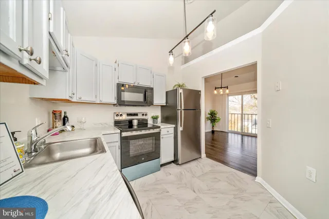 a kitchen with stainless steel appliances granite countertop a refrigerator a stove top oven a sink and dishwasher