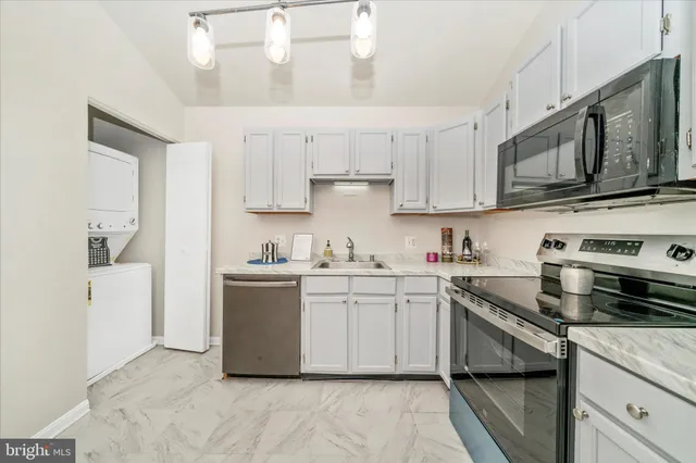 a kitchen with stainless steel appliances white cabinets a sink and a stove