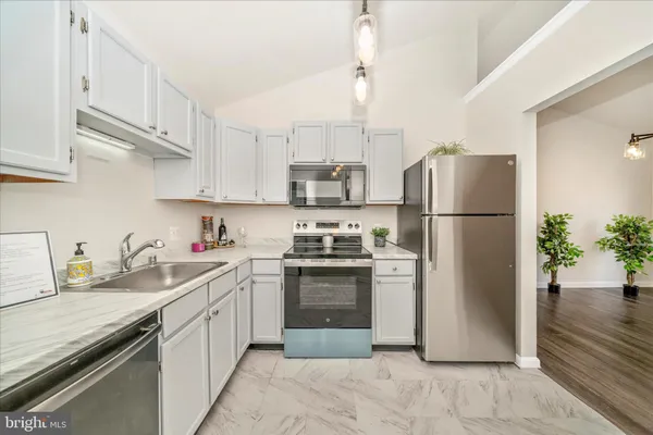 a kitchen with stainless steel appliances granite countertop a refrigerator sink and stove