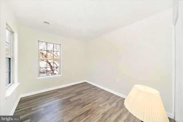 an empty room with wooden floor and a window
