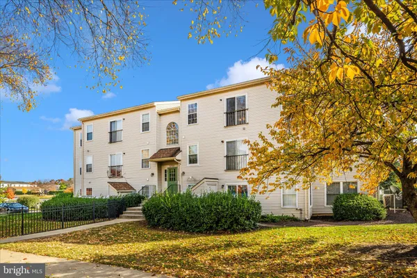 a view of a white building with a yard