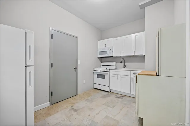 a kitchen with white cabinets and white appliances