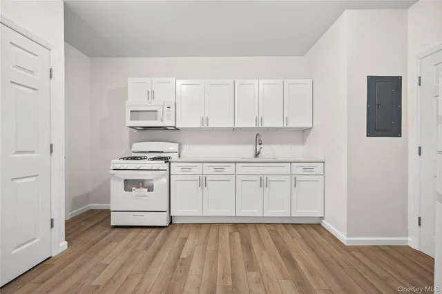 a kitchen with granite countertop white cabinets and white appliances