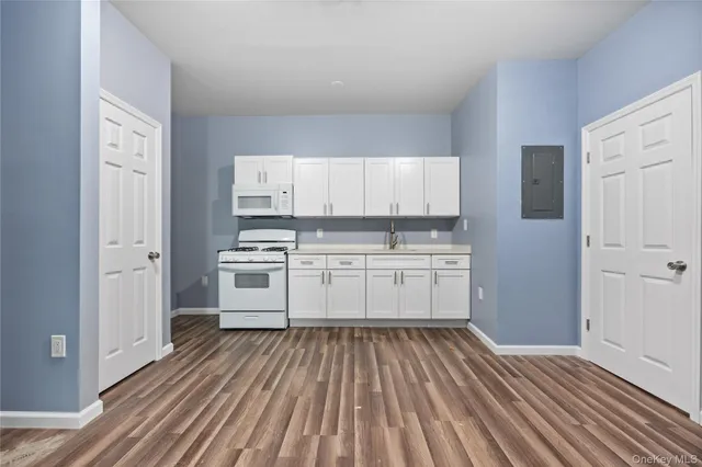 a kitchen with white cabinets stainless steel appliances and a window