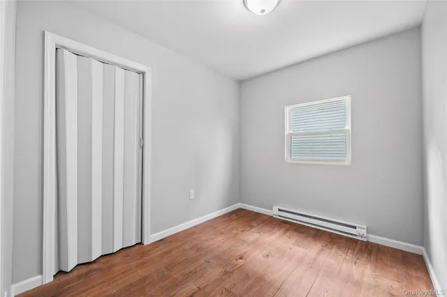 a view of a room with wooden floor and a window