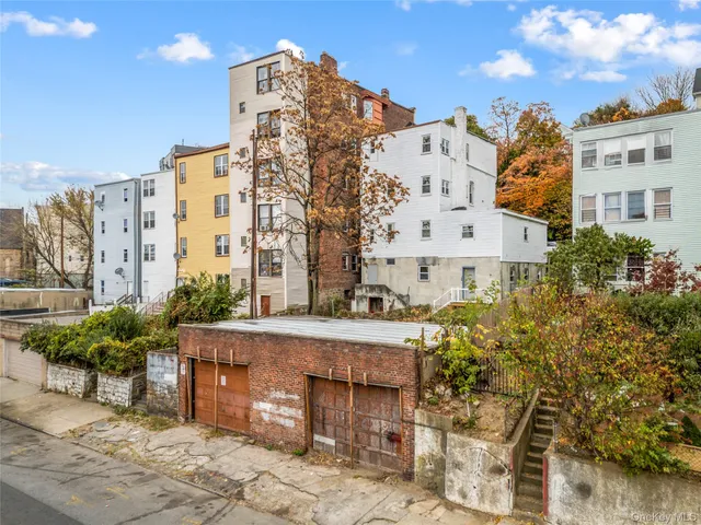 a view of a building with garden space and sitting area