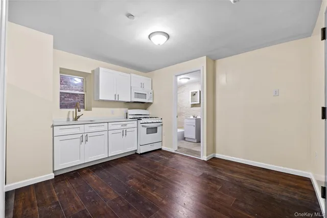 a kitchen with granite countertop white cabinets and white appliances