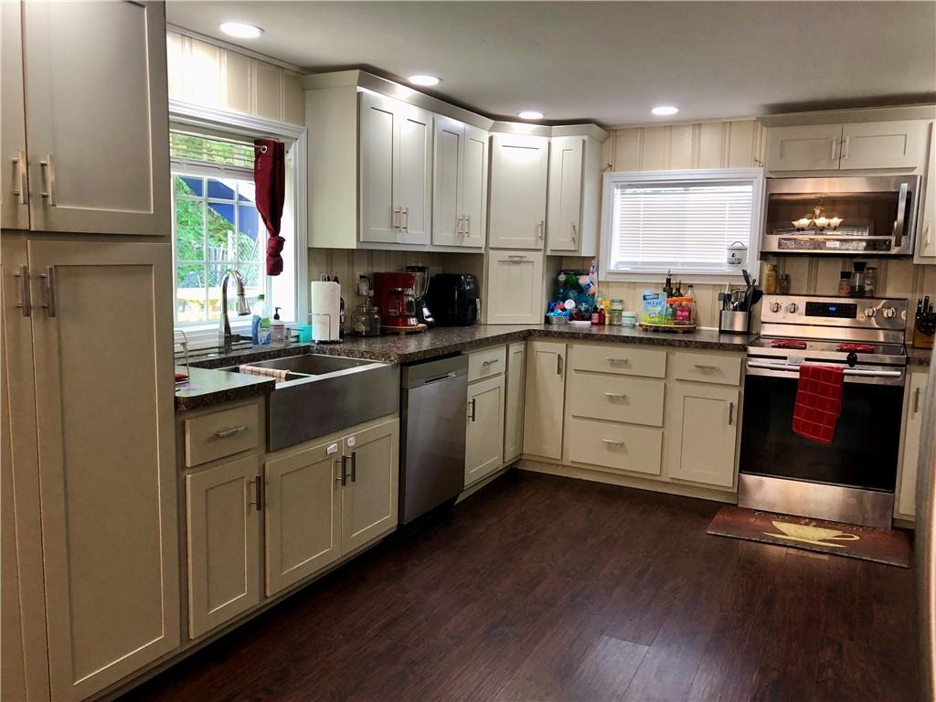 203 Lighthouse Road Commodore, PA 15729 - Photo 3 of 16 a kitchen with stainless steel appliances granite countertop a stove sink and cabinets