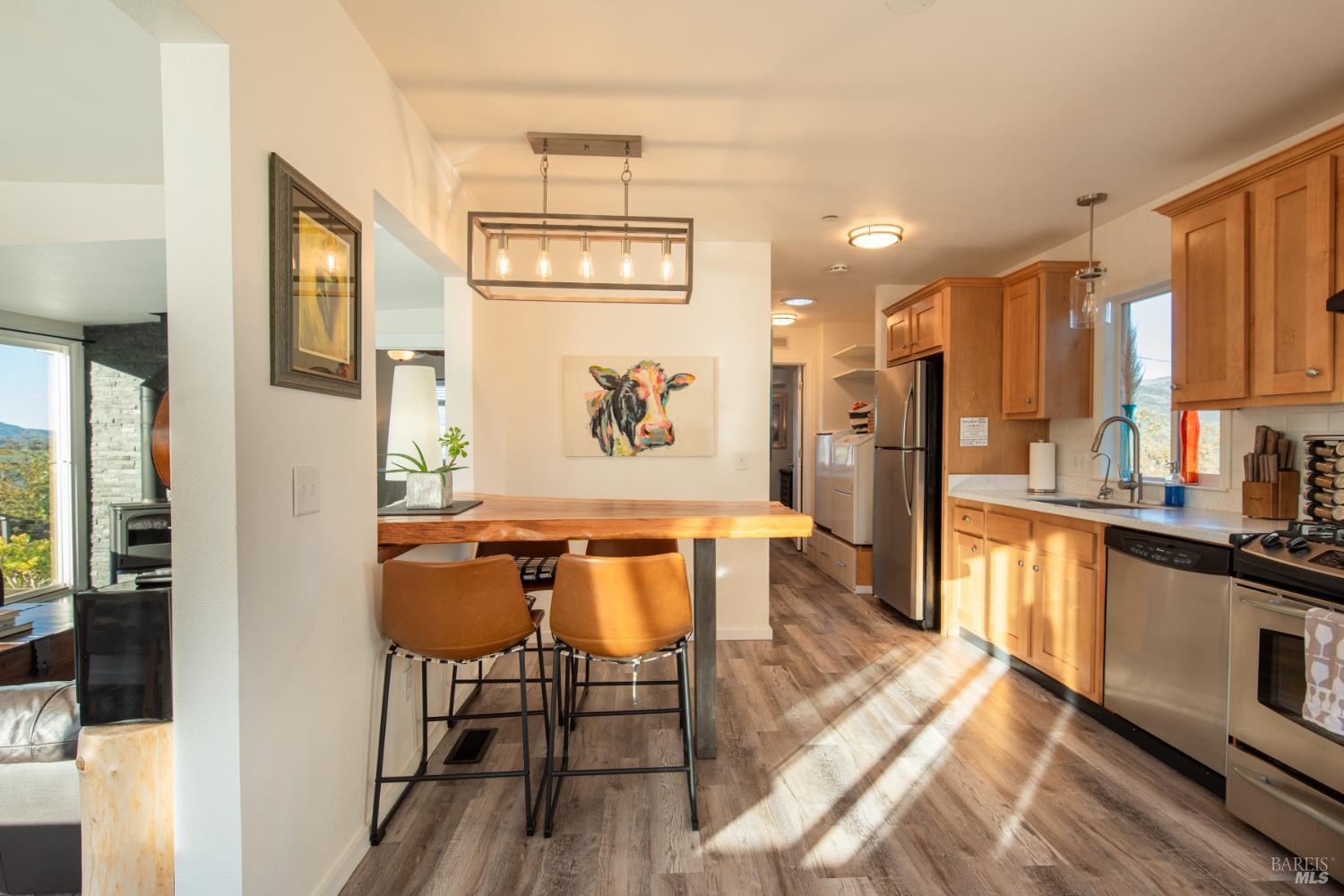 22855 Chianti Road Geyserville, CA 95411 - Photo 36 of 76 a dining room with stainless steel appliances kitchen island granite countertop furniture and a wooden floor