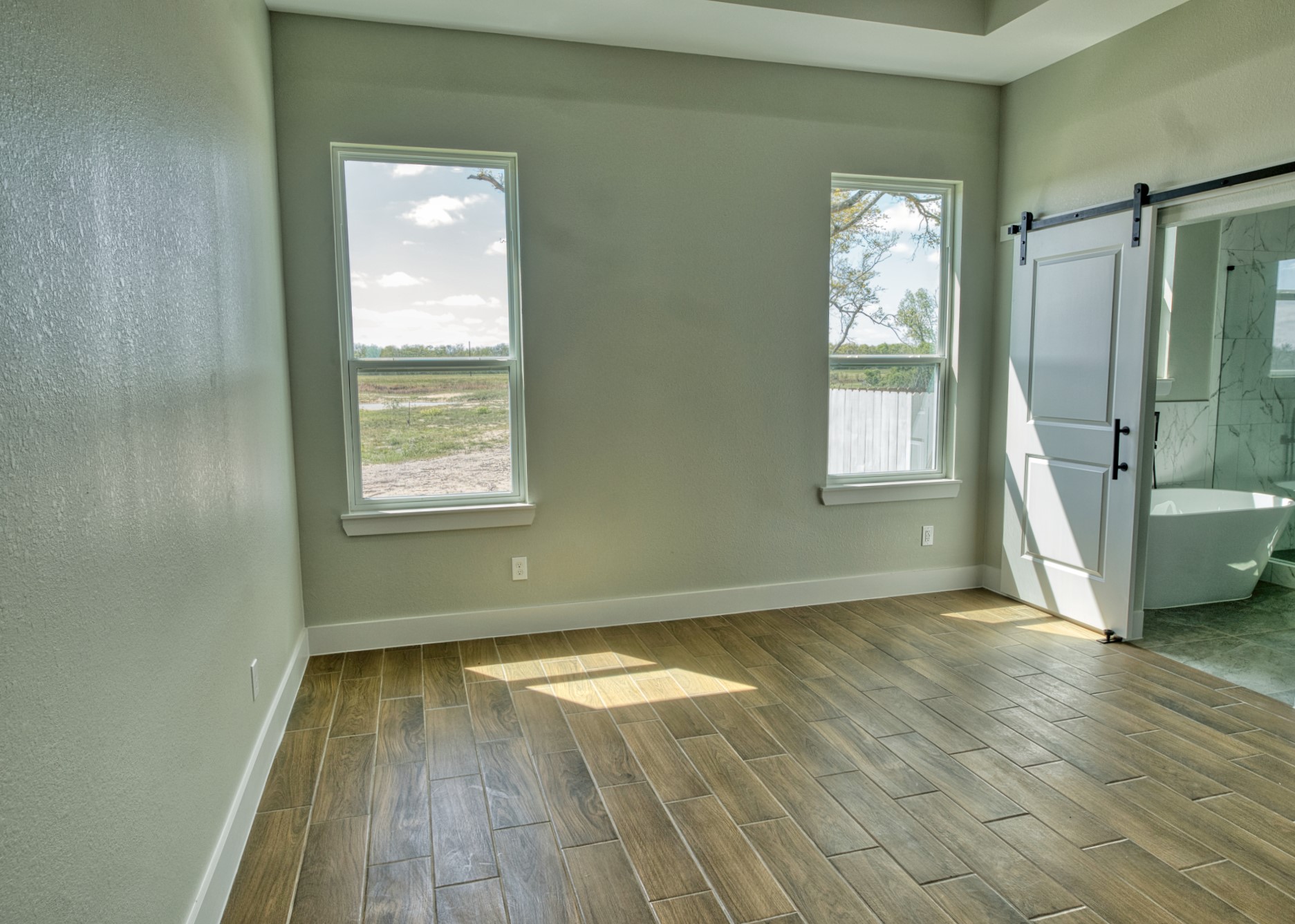 925 Buffalo Trail Angleton, TX 77515 - Photo 27 of 45 an empty room with wooden floor and windows