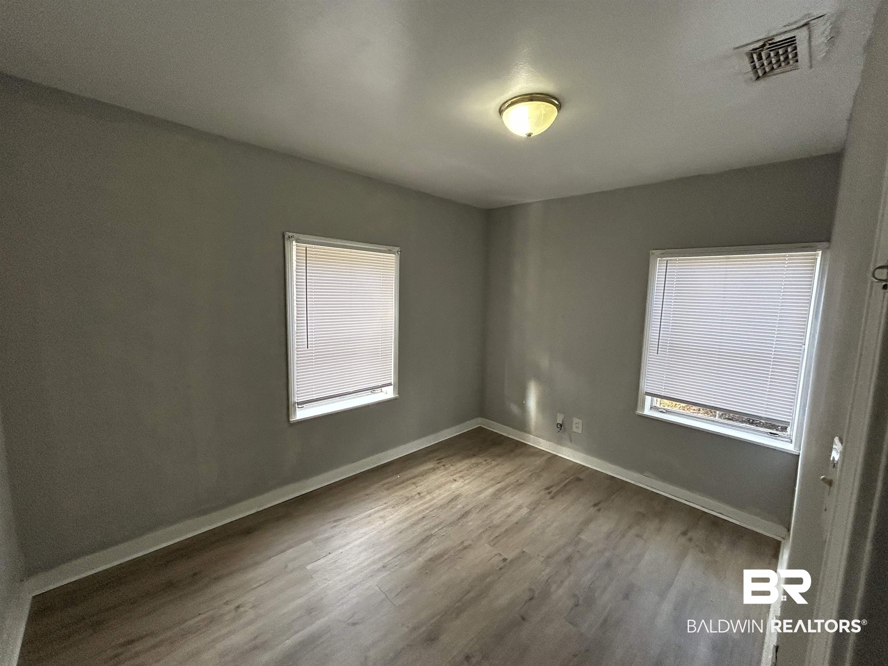 2119 Hoppin Street Mobile, AL 36605 - Photo 20 of 23 Spare room featuring a healthy amount of sunlight and wood-type flooring