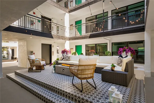 a view of a patio with couches table and chairs and potted plants