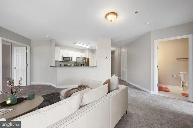 a living room with furniture and view of kitchen