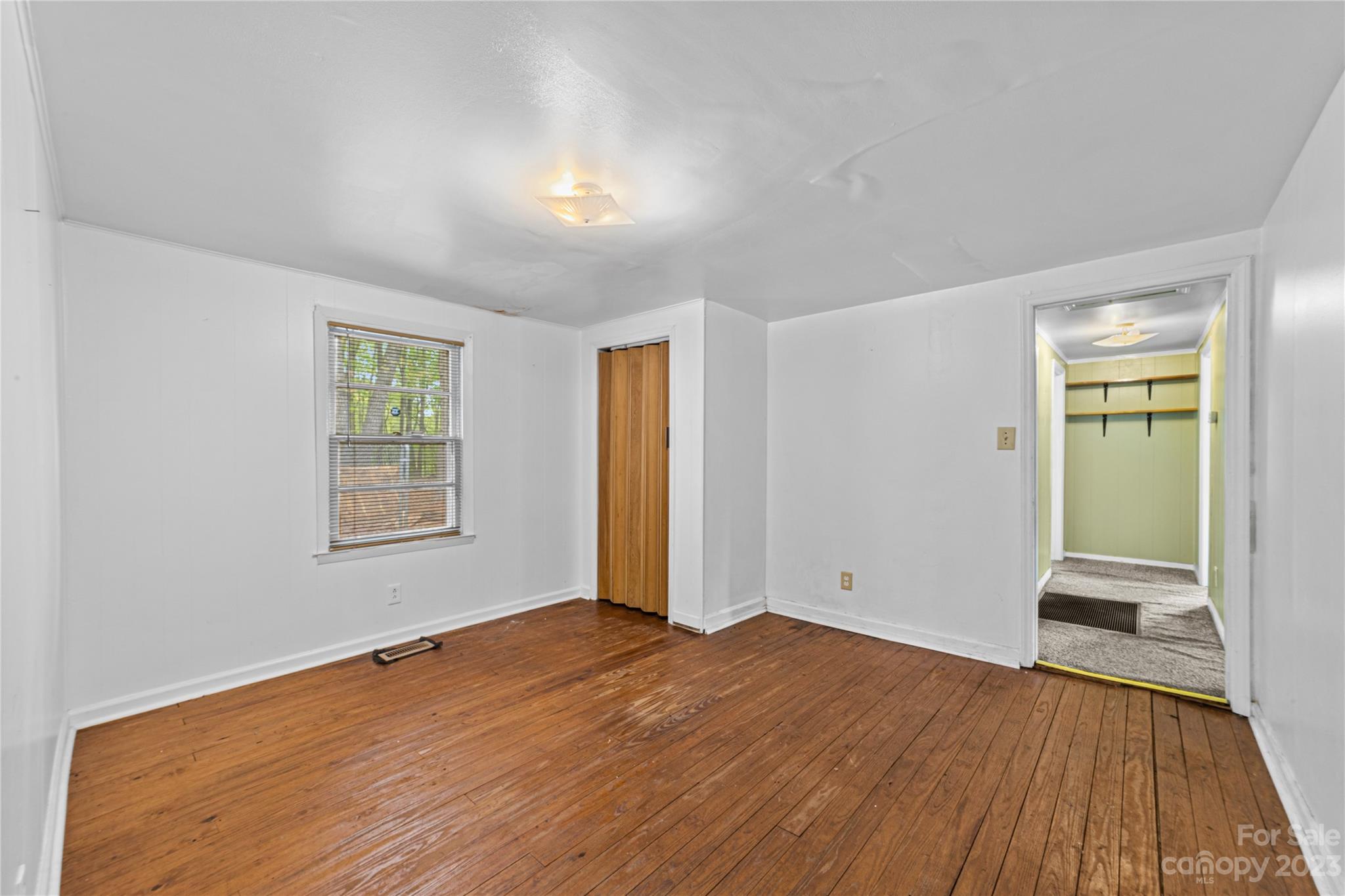 5641 Anderson Road Charlotte, NC 28269 - Photo 14 of 27 an empty room with wooden floor and windows