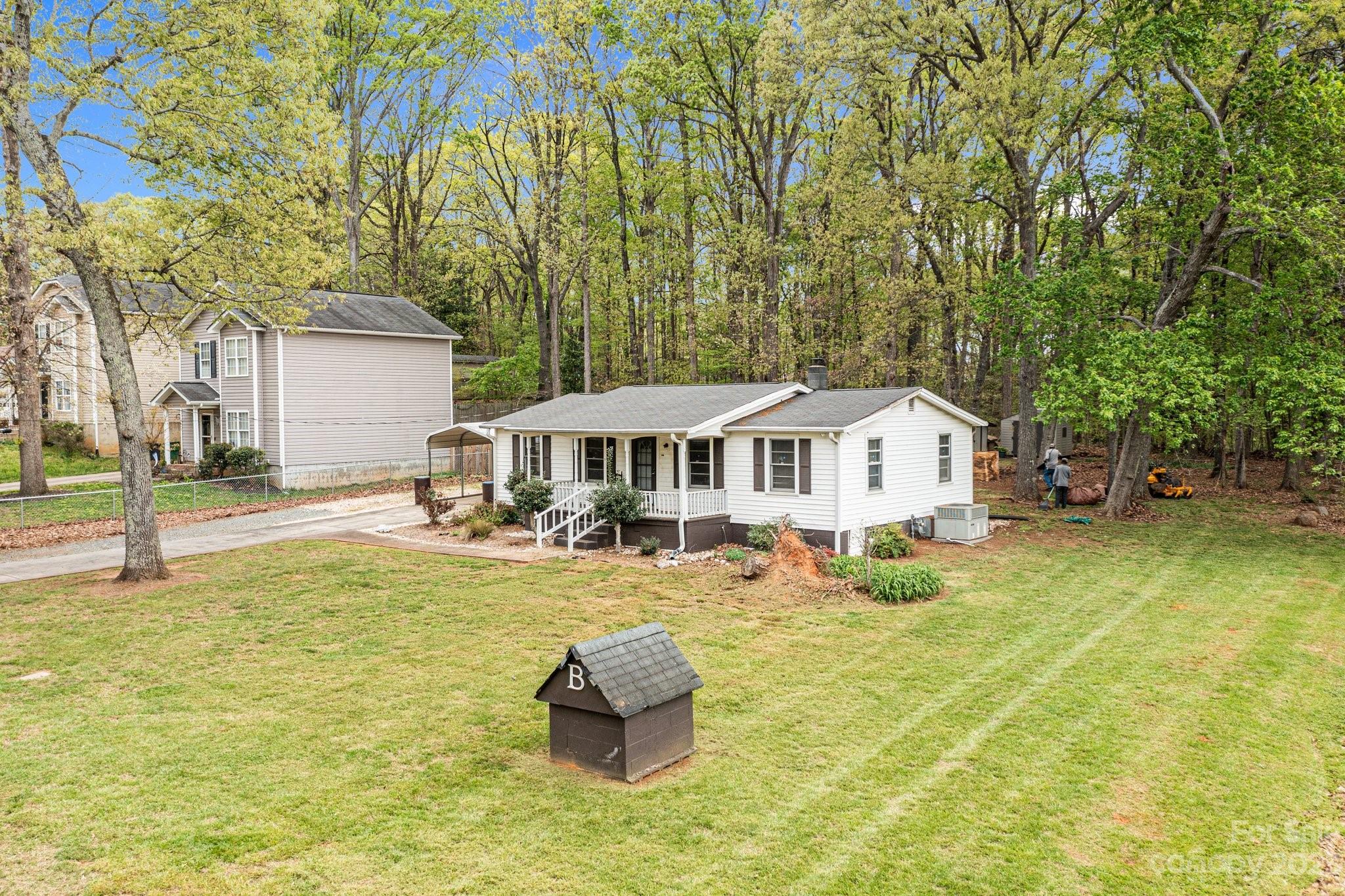 5641 Anderson Road Charlotte, NC 28269 - Photo 3 of 27 a house that has a big yard with table and chairs under an umbrella