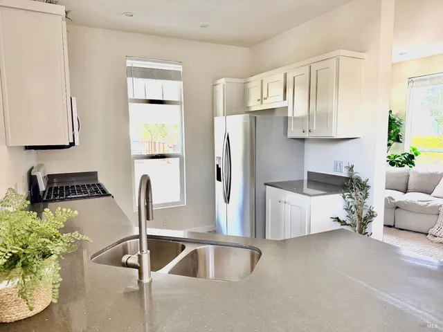 a kitchen with stainless steel appliances granite countertop a refrigerator a stove and a sink