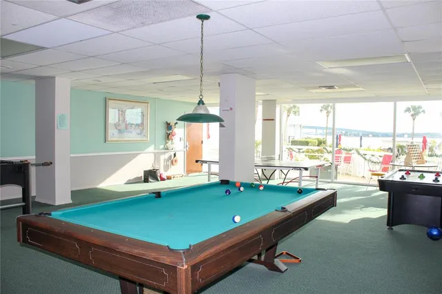 a room with pool table and windows