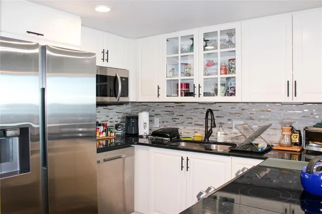 a kitchen with stainless steel appliances granite countertop a refrigerator and a sink