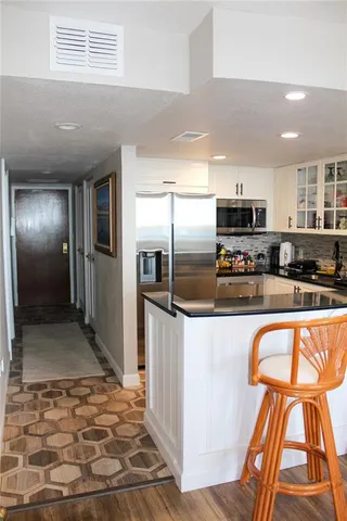 a kitchen with stainless steel appliances granite countertop a refrigerator and a stove