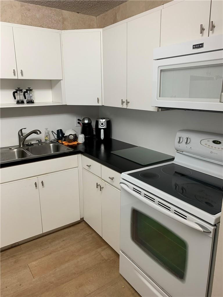 200 Southeast 15th Road, Unit 11H Miami, FL 33129 - Photo 25 of 35 a kitchen with white cabinets and white appliances