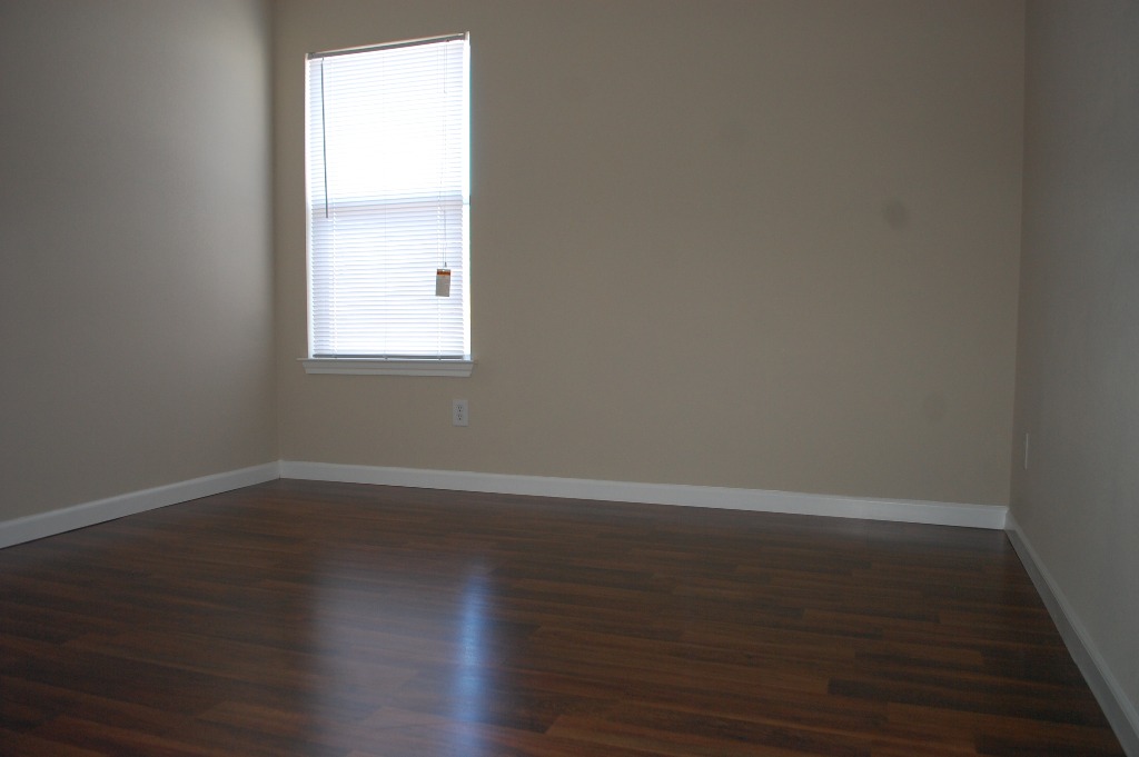 11300 Dimmit Street Manor, TX 78653 - Photo 18 of 23 Rich hardwood floors complement the neutral walls in this bright, empty room.