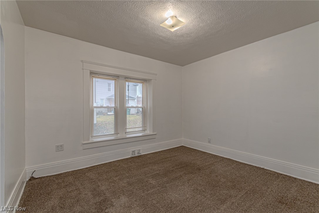 471 Rentschler Street Akron, OH 44304 - Photo 15 of 16 Carpeted spare room featuring a textured ceiling