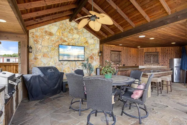 a view of a patio with chairs and a grill