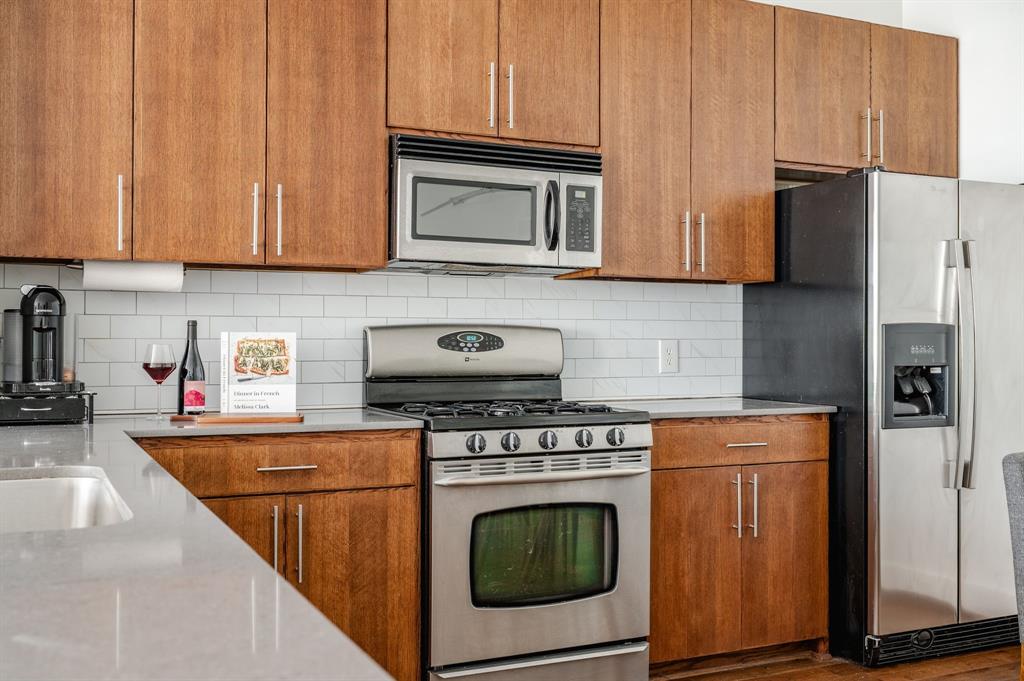3930 Bowser Avenue, Unit 11 Dallas, TX 75219 - Photo 17 of 39 a kitchen with stainless steel appliances granite countertop a refrigerator stove and sink
