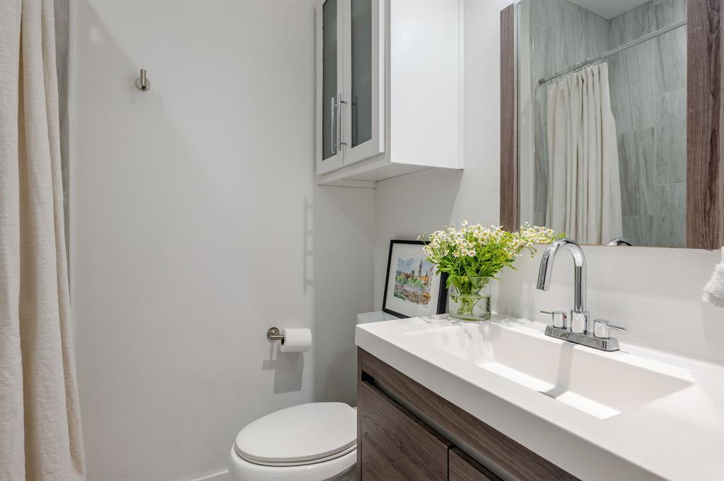 3930 Bowser Avenue, Unit 11 Dallas, TX 75219 - Photo 32 of 39 a bathroom with a granite countertop toilet sink and mirror