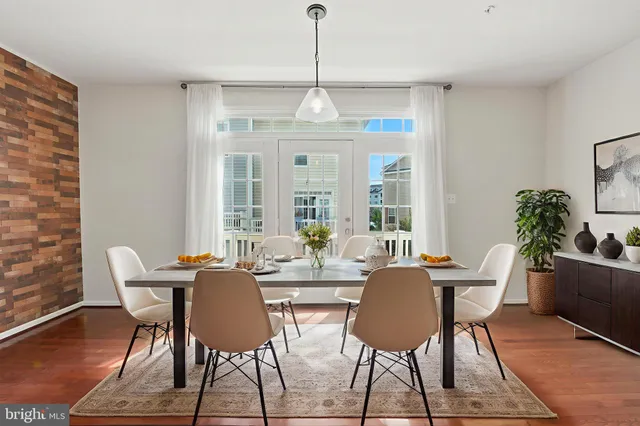 a dining room with furniture a chandelier and wooden floor